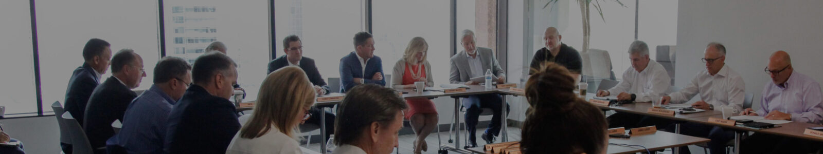 A group of professionals sitting in a row on a panel addressing an audience