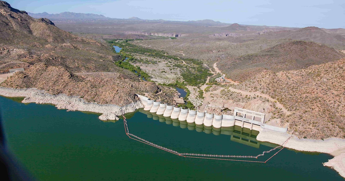 A dam blocks a large body of water from mountains