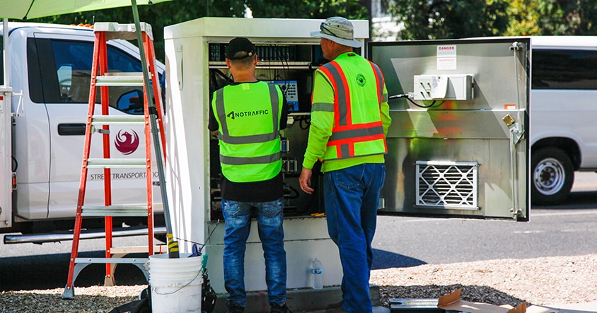 Two technicians installing No Traffic signals at City of Phoenix intersection