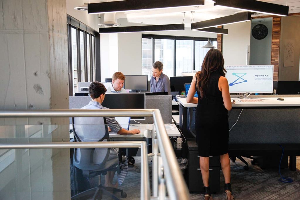 four employees at work in open office space