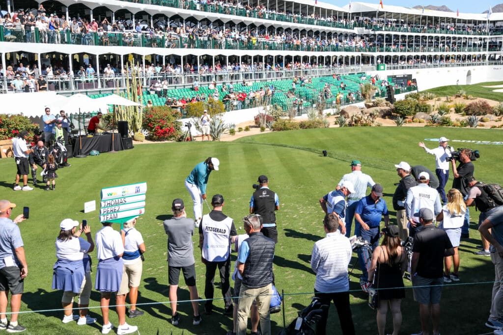 A crowd gathered around Larry Fitzgerald at WM Phoenix Open watching him golf.