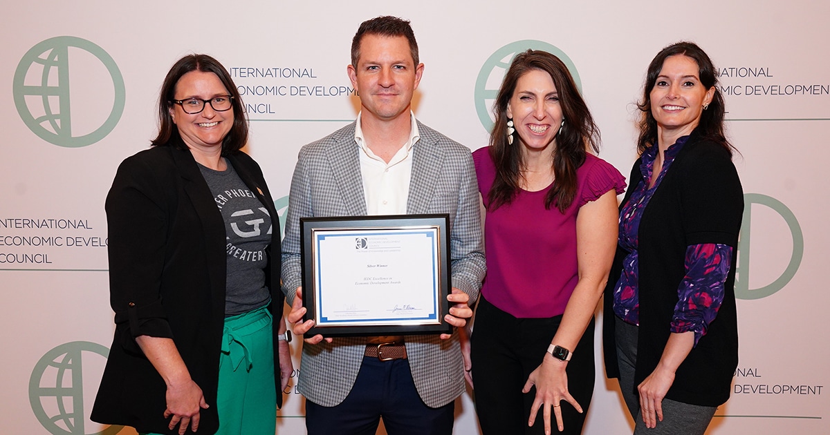 Four GPEC staff members pose with a plaque distinguishing the organization's as IEDC's top EDO in the U.S.