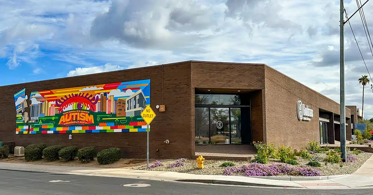 A large one-story office building with a colorful mural on the left side and Goodmans logo on the right.