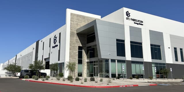 The exterior of a large building with two GTI Fabrication logos.