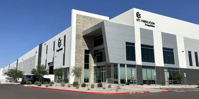 The exterior of a large building with two GTI Fabrication logos.