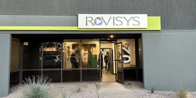 A gray building with a white-and-green sign baring the RoviSys logo.