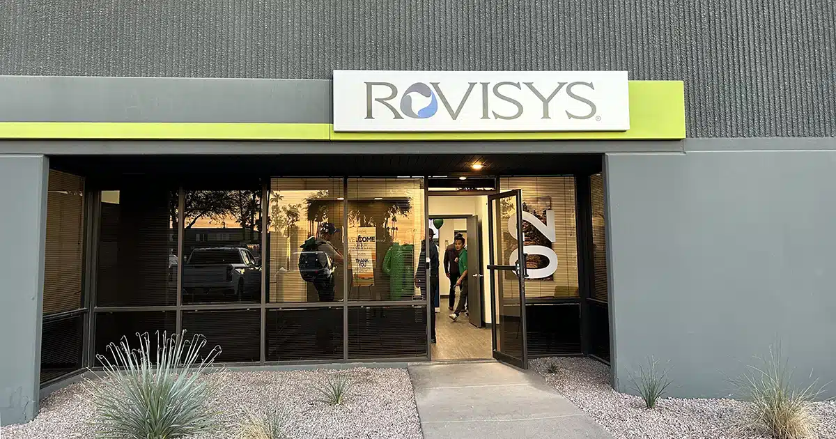 A gray building with a white-and-green sign baring the RoviSys logo.